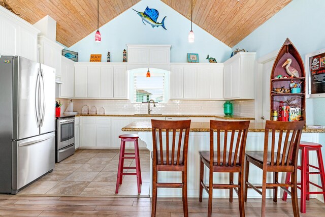 kitchen featuring a kitchen bar, sink, hanging light fixtures, and appliances with stainless steel finishes