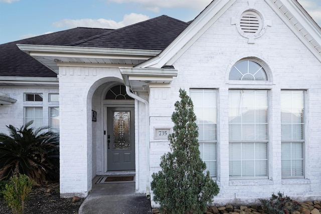 735 Jacob Cir, Orange, TX 77630 - property entrance featuring roof with shingles, brick siding, and a garage