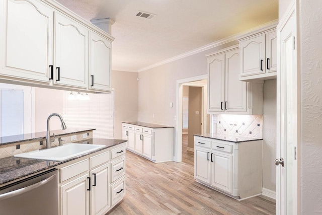 kitchen featuring white cabinetry, sink, stainless steel dishwasher, light hardwood / wood-style floors, and ornamental molding