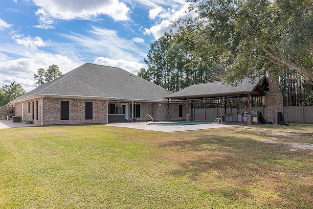 rear view of house featuring a fenced in pool, a yard, and a patio