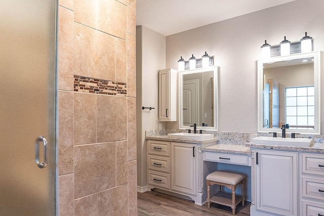 bathroom featuring hardwood / wood-style floors, vanity, and a shower with door