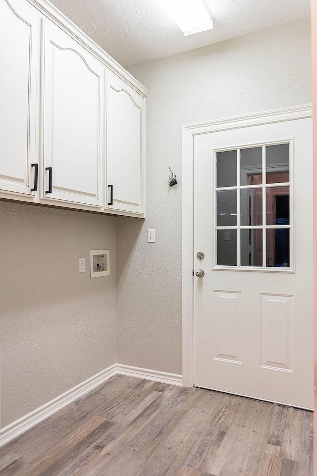 laundry room featuring washer hookup, cabinets, and light hardwood / wood-style floors