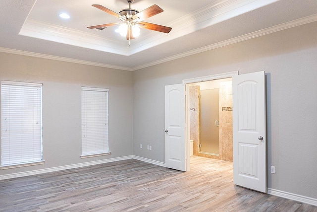 unfurnished room with a tray ceiling, ceiling fan, ornamental molding, and light hardwood / wood-style floors