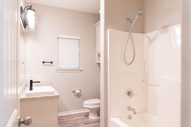 full bathroom with hardwood / wood-style floors, vanity, toilet, and shower / washtub combination