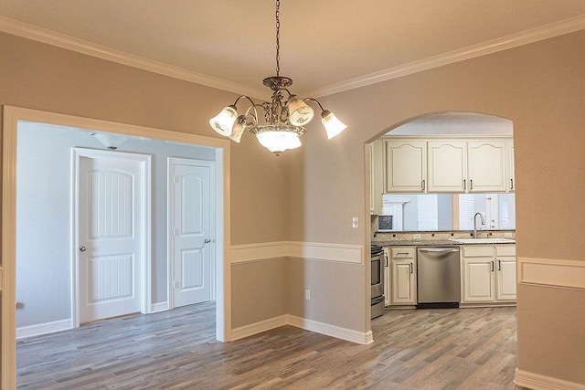 kitchen featuring an inviting chandelier, sink, hanging light fixtures, ornamental molding, and appliances with stainless steel finishes