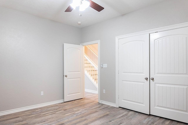 unfurnished bedroom featuring ceiling fan, light hardwood / wood-style flooring, and a closet