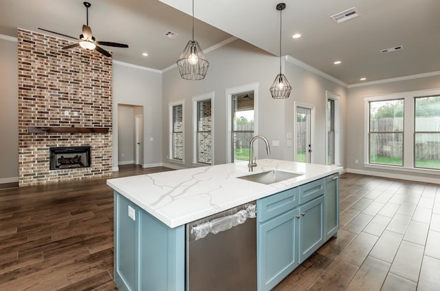 kitchen featuring pendant lighting, a kitchen island with sink, sink, and stainless steel dishwasher