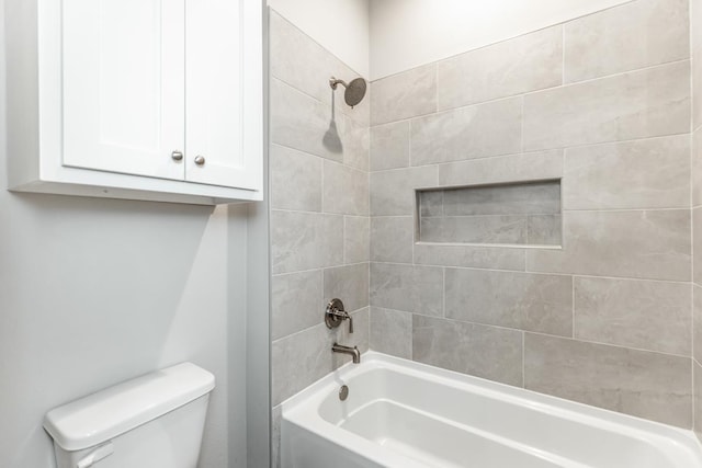 bathroom featuring tiled shower / bath combo and toilet