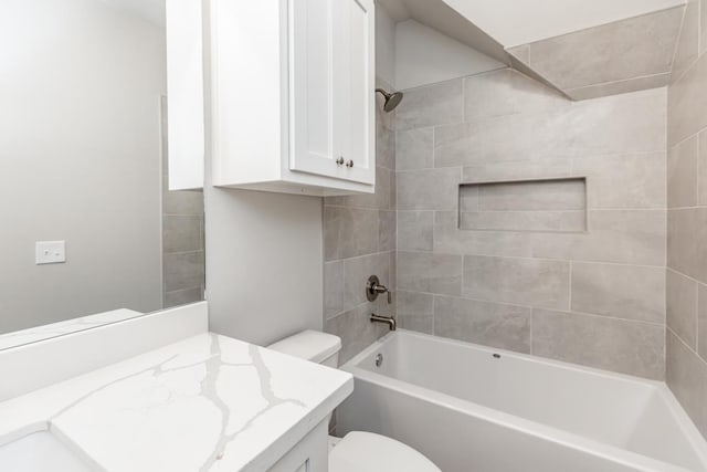 full bathroom featuring vanity, tiled shower / bath combo, and toilet