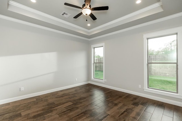 empty room featuring dark hardwood / wood-style floors, ceiling fan, a raised ceiling, and crown molding