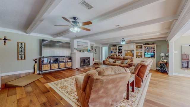 310 Junker Rd, Beaumont, TX 77707 - living area with ceiling fan, beam ceiling, light wood finished floors, crown molding, and a fireplace with raised hearth
