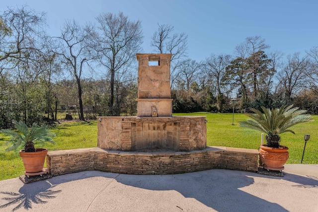 310 Junker Rd, Beaumont, TX 77707 - view of patio / terrace with an outdoor stone fireplace and view of scattered trees