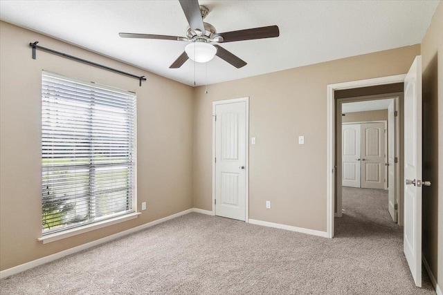 unfurnished bedroom with ceiling fan, light colored carpet, and a closet