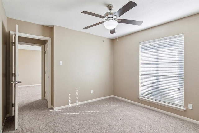 carpeted spare room with ceiling fan