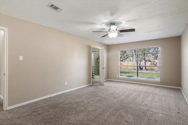 carpeted spare room with ceiling fan and a textured ceiling