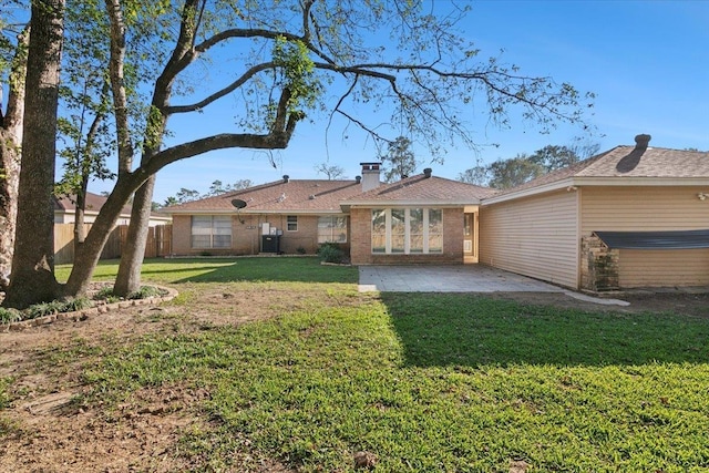 rear view of house with cooling unit, a yard, and a patio