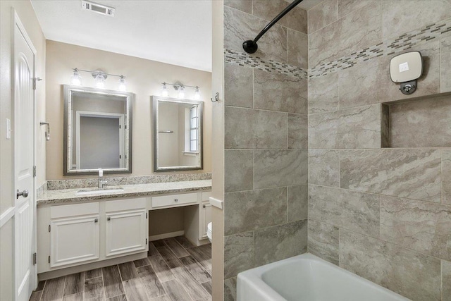 bathroom with vanity and tiled shower / bath