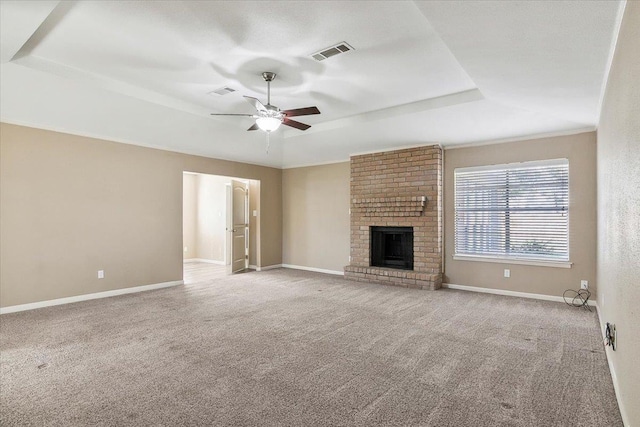 unfurnished living room with a fireplace, light colored carpet, a raised ceiling, and ceiling fan