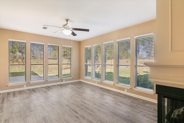 interior space with hardwood / wood-style floors, ceiling fan, and a multi sided fireplace