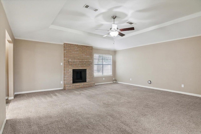 unfurnished living room with a raised ceiling, ceiling fan, a fireplace, and carpet floors