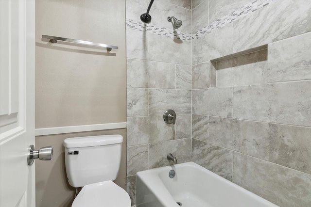 bathroom with tiled shower / bath combo and toilet