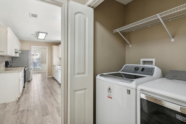 washroom featuring washer and dryer and light hardwood / wood-style floors