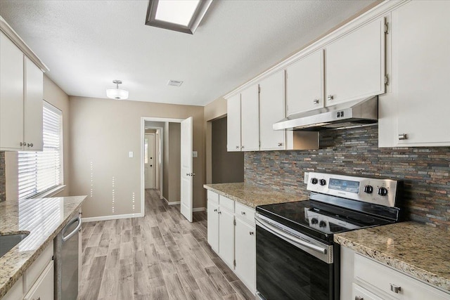 kitchen with light stone counters, white cabinets, stainless steel appliances, and light wood-type flooring