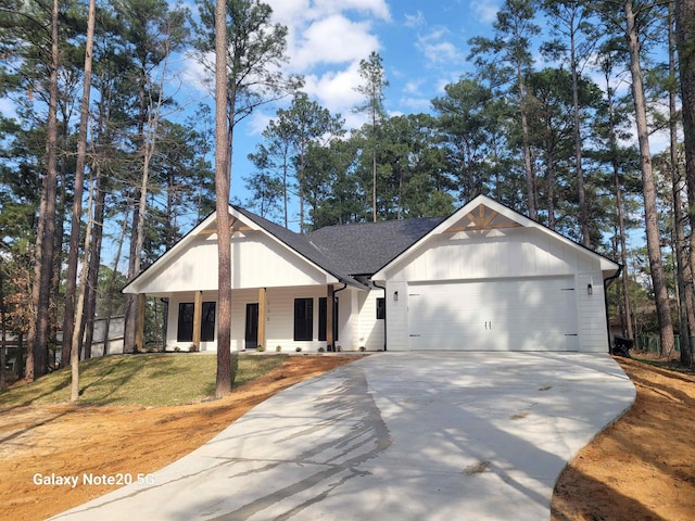 view of front of property featuring a garage, a front lawn, and a porch