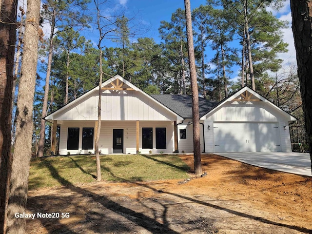 view of front of property featuring a porch, a garage, and a front yard