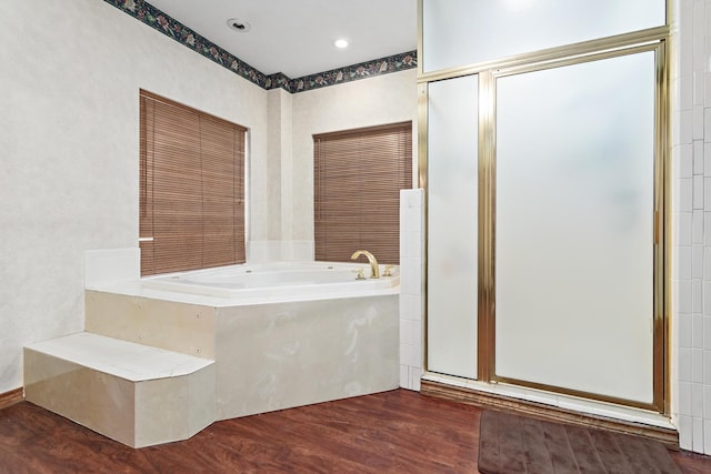 bathroom featuring wood-type flooring and a tub to relax in