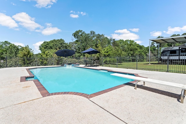 view of pool with a lawn, a diving board, and a patio