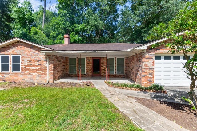 10754 Bonwell Loop, Kountze, TX 77625 - ranch-style home with a garage, a chimney, a front lawn, and brick siding