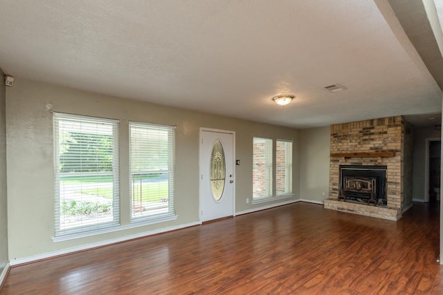 10754 Bonwell Loop, Kountze, TX 77625 - unfurnished living room with wood finished floors and a brick fireplace