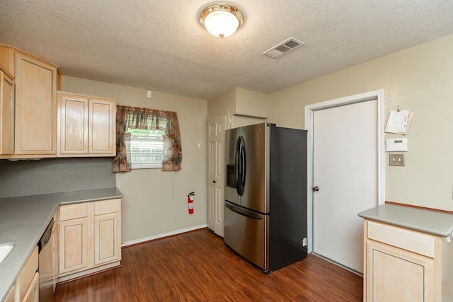 10754 Bonwell Loop, Kountze, TX 77625 - kitchen with appliances with stainless steel finishes, light brown cabinetry, dark wood-style flooring, a textured ceiling, and light countertops