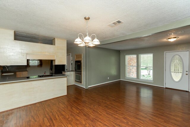 10754 Bonwell Loop, Kountze, TX 77625 - kitchen with a chandelier, dark wood finished floors, black electric cooktop, a textured ceiling, and stainless steel double oven