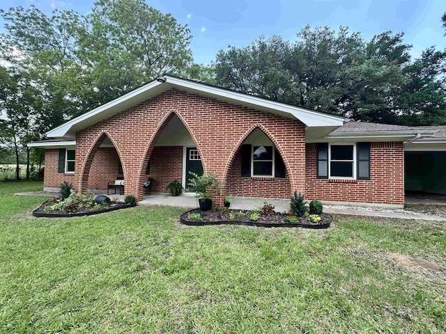 ranch-style house featuring an attached carport, a front lawn, and brick siding