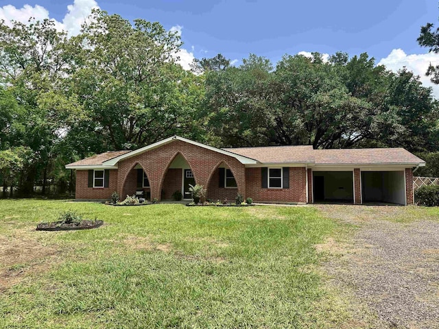 ranch-style house with an attached garage, a front yard, driveway, and brick siding