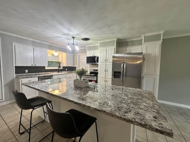 kitchen featuring light tile patterned floors, appliances with stainless steel finishes, white cabinetry, and a sink
