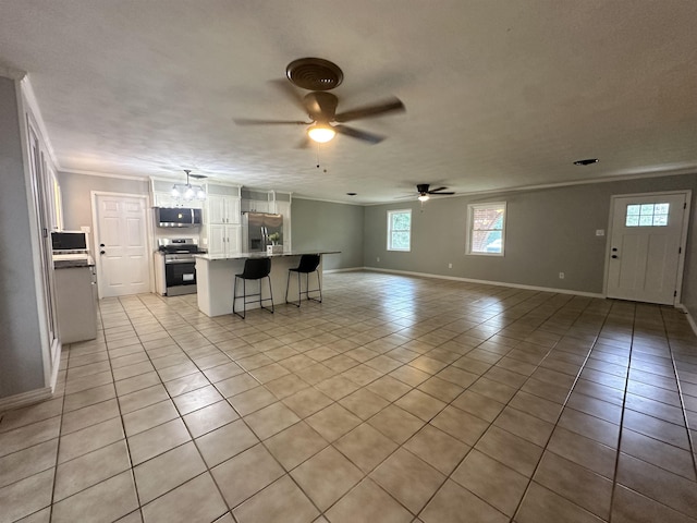living room with crown molding, light tile patterned flooring, a ceiling fan, and baseboards