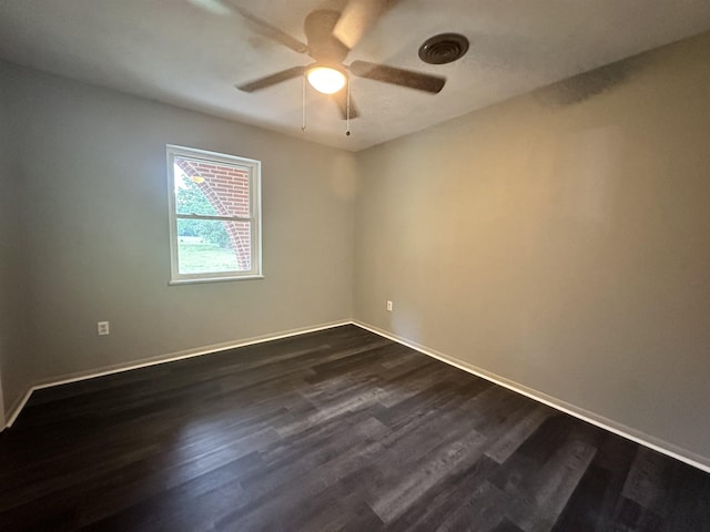 empty room featuring a ceiling fan, baseboards, and dark wood-style floors