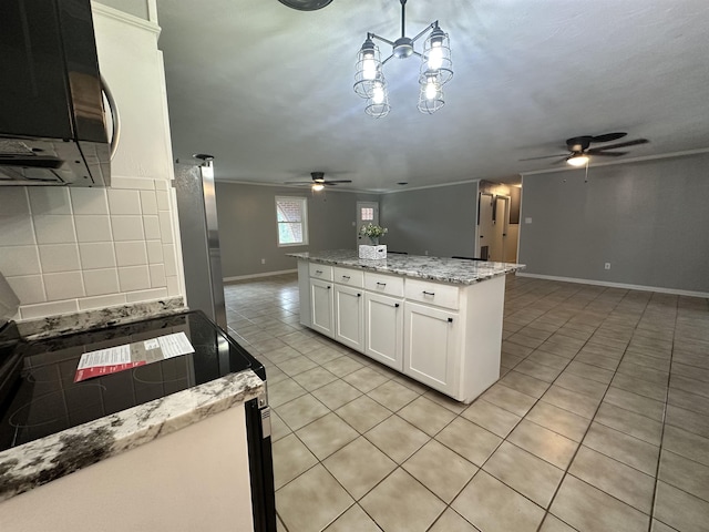 kitchen featuring baseboards, a ceiling fan, light tile patterned floors, and open floor plan