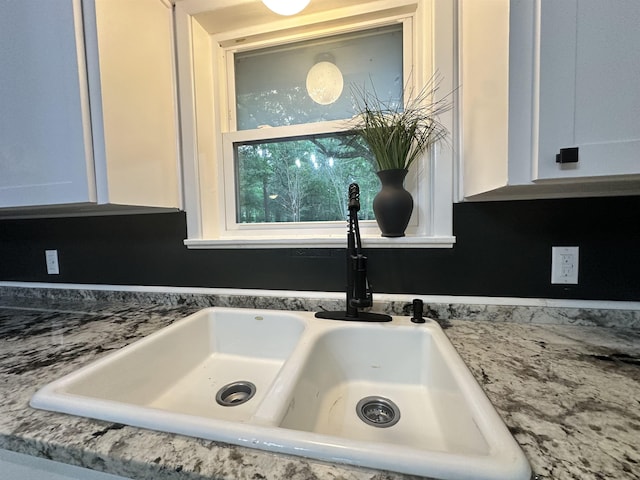 details with a sink and white cabinets