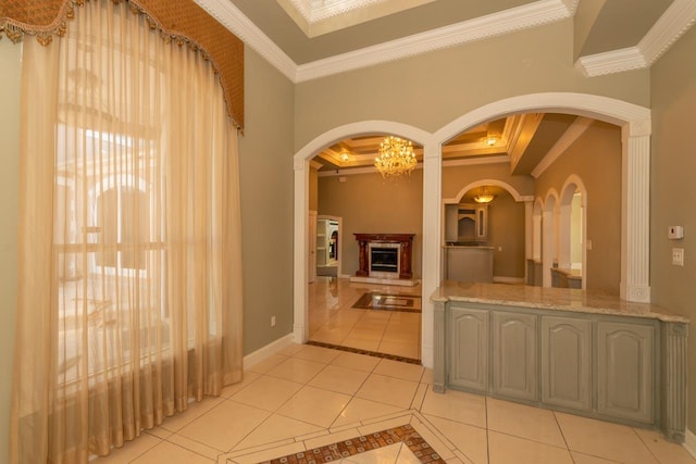 bathroom featuring tile patterned floors, crown molding, baseboards, and a fireplace with raised hearth