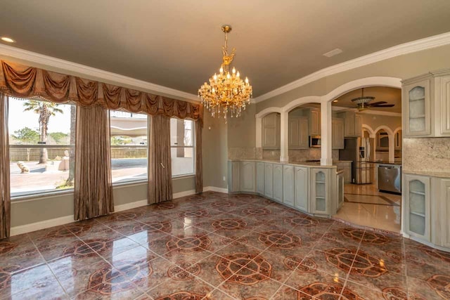 unfurnished room featuring crown molding, baseboards, ceiling fan with notable chandelier, arched walkways, and marble finish floor