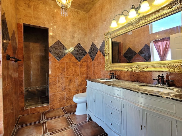 bathroom with double vanity, toilet, tile walls, and a sink