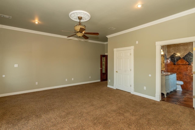 unfurnished bedroom featuring carpet, baseboards, visible vents, ensuite bath, and ornamental molding