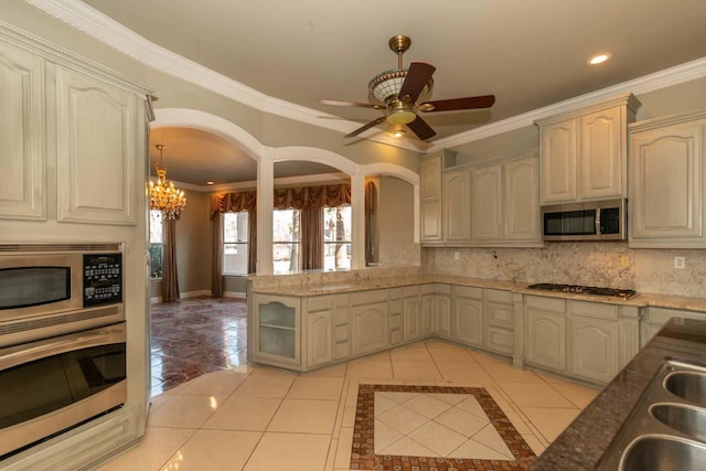 kitchen featuring light tile patterned floors, tasteful backsplash, appliances with stainless steel finishes, and a sink