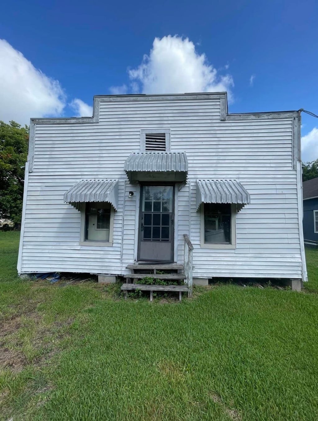 rear view of property with a lawn