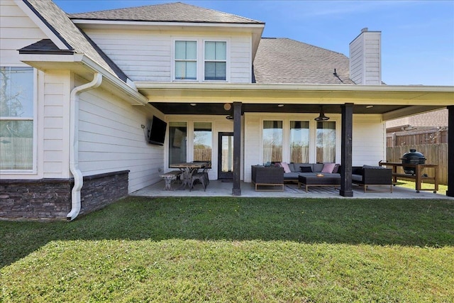 rear view of property featuring fence, an outdoor hangout area, a chimney, a yard, and a patio area