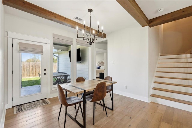 dining room with light wood-type flooring, visible vents, beamed ceiling, an inviting chandelier, and stairs